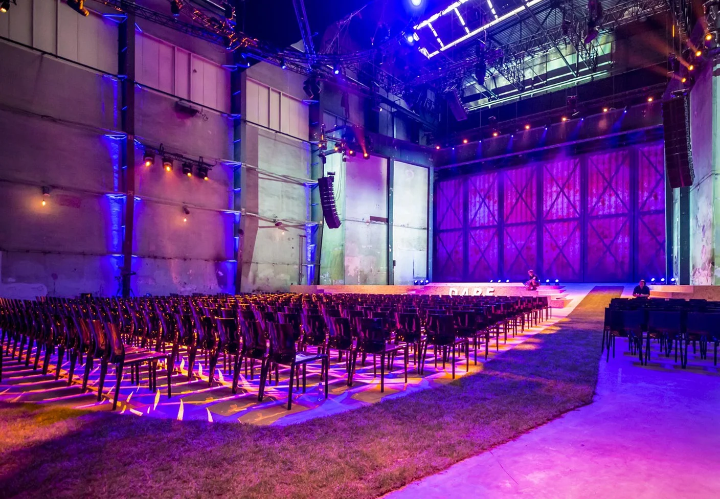 Equipo de sonido profesional, iluminación led colorida y mobiliario elegante en salón de eventos vacío listo para perturar